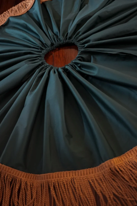 Forest green cotton sateen tree skirt laid flat with gathered pleats around the centre opening and bronze bullion fringe edge