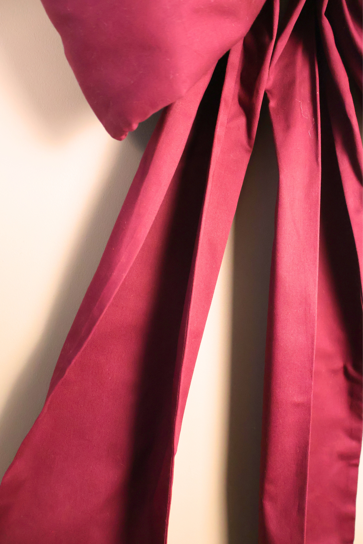 Detail of the burgundy bow tails falling in soft folds