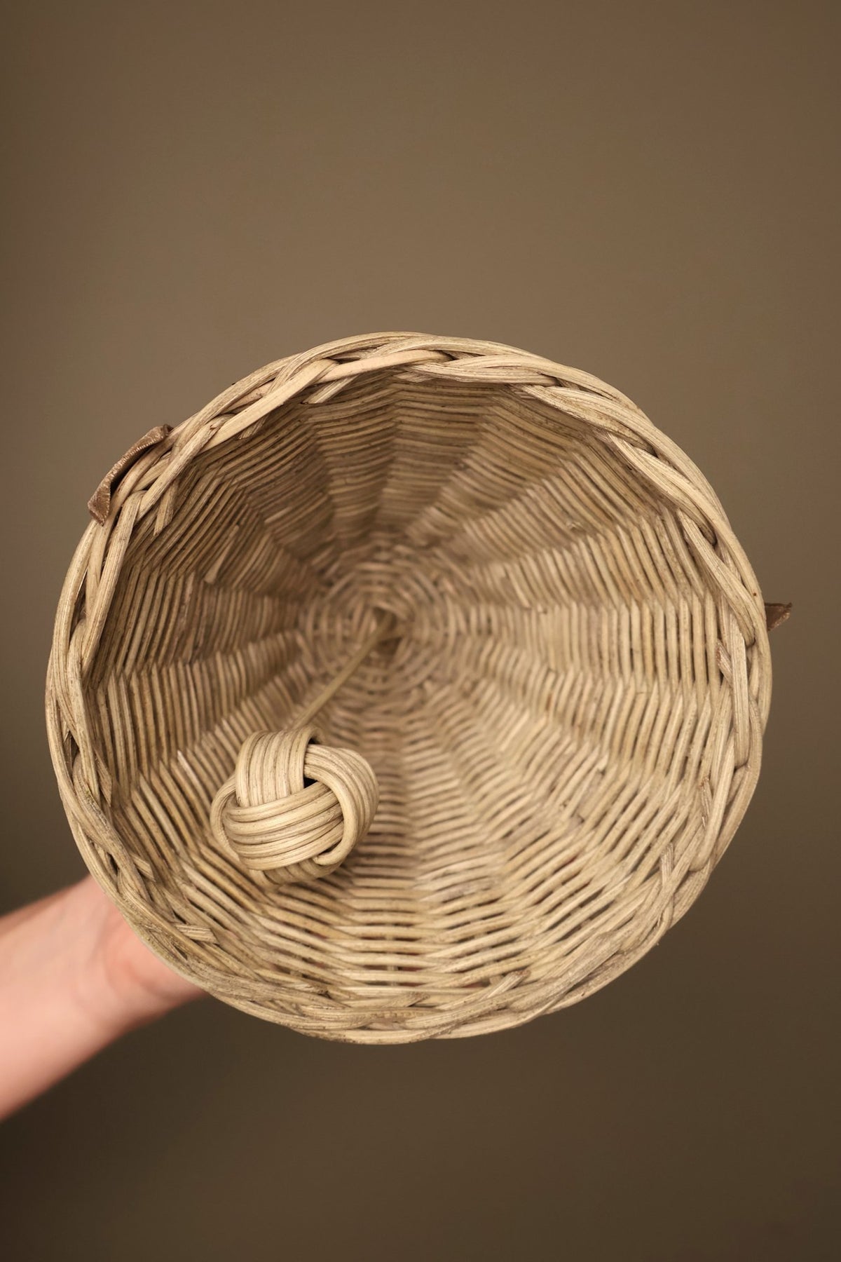 Inside of a medium Noël rattan bell showing the woven rattan and the knotted clapper that gives its soft chime
