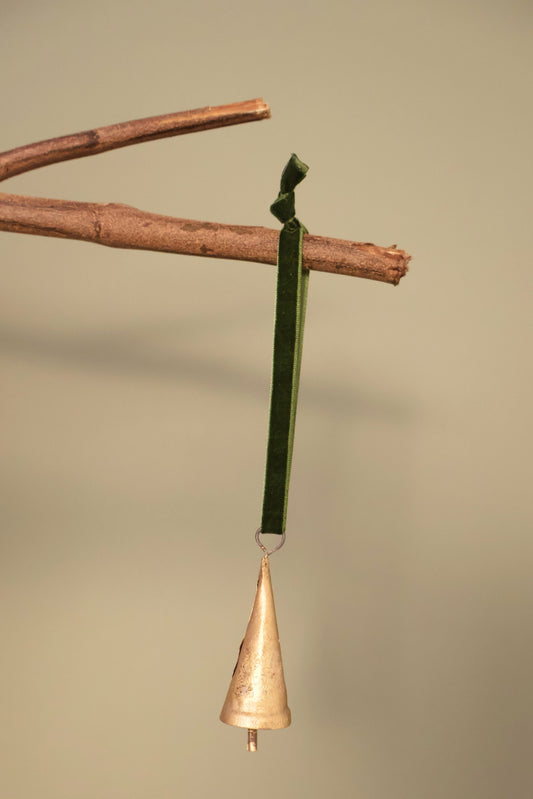 Bijou Rustic Cone Bell in antique gold hanging from a branch on an olive green velvet ribbon