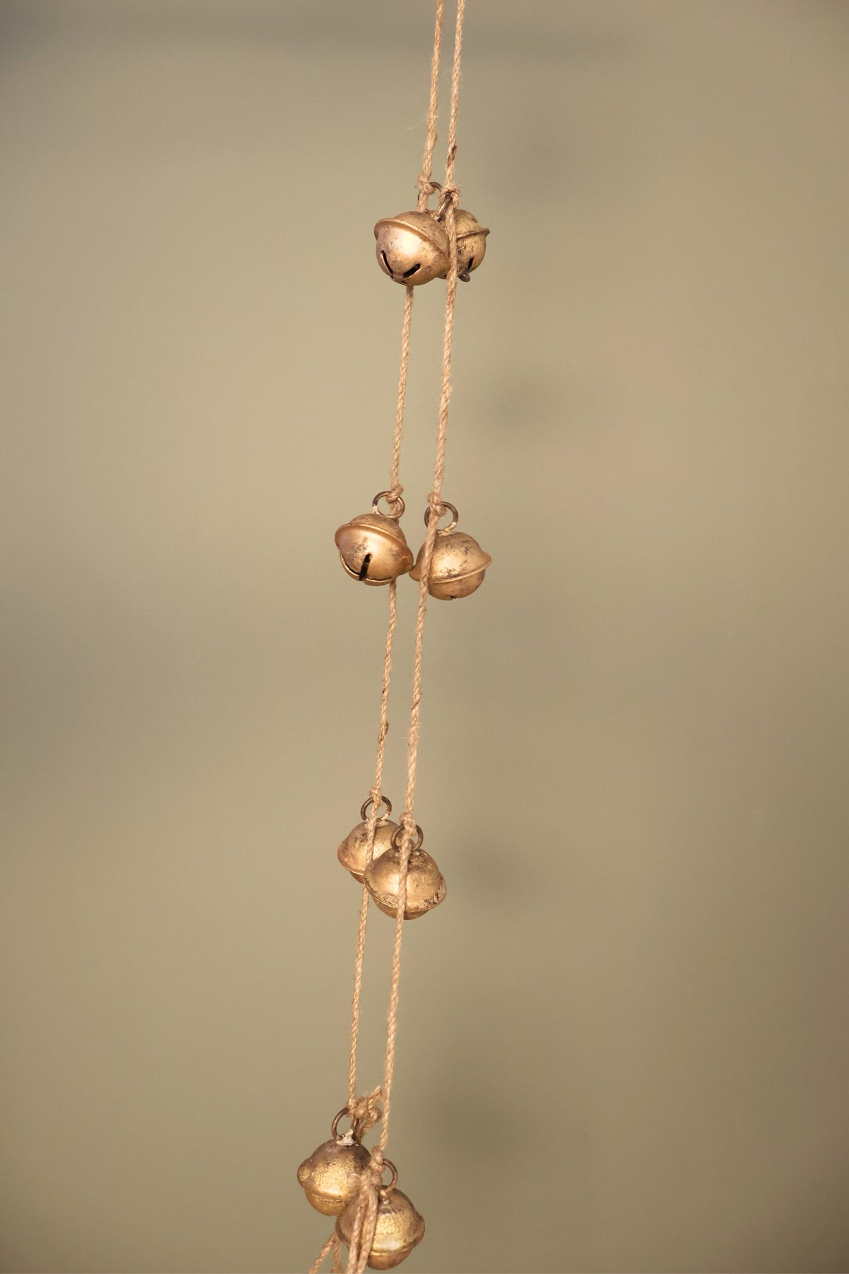 Bijou Rustic Bell Garland: close view of small antique gold jingle bells in clusters on natural jute cord