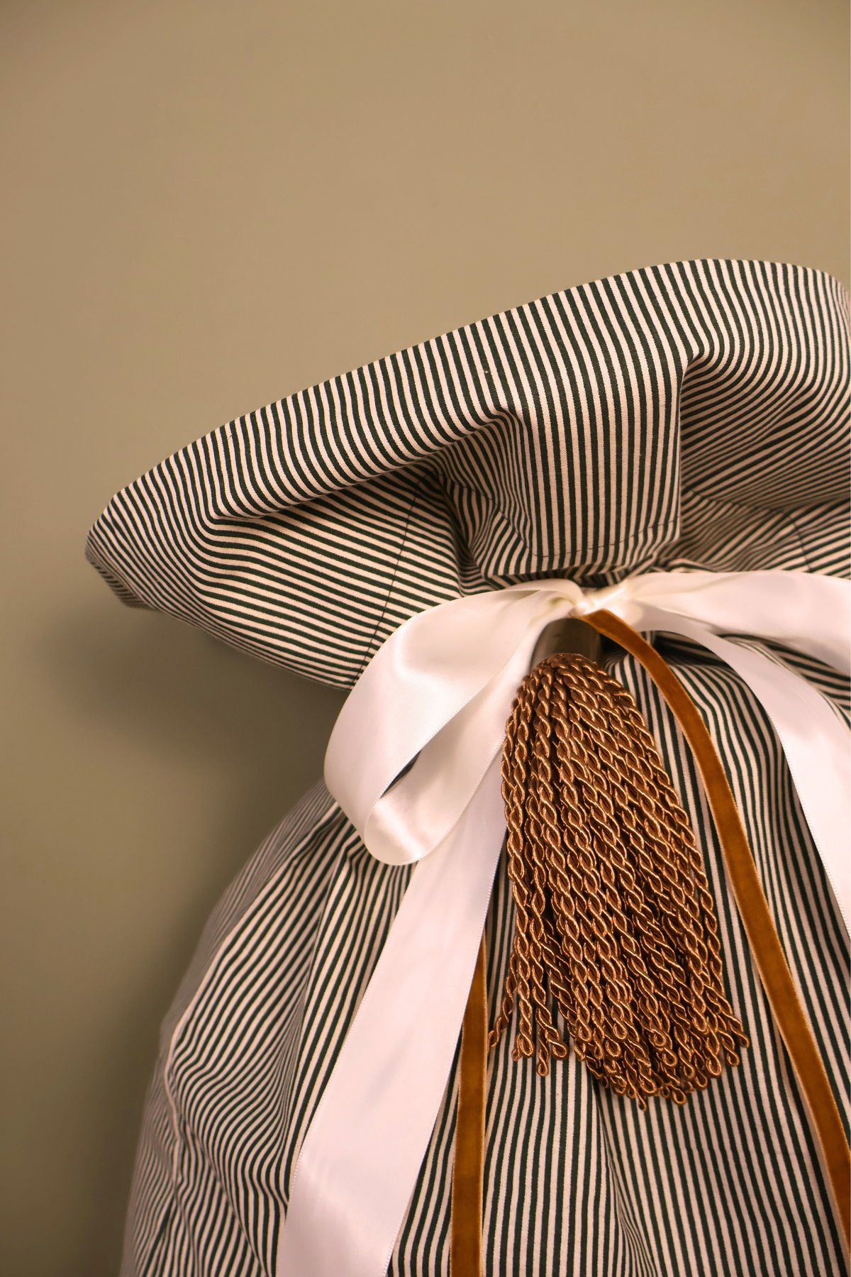 Close up of the Santa sack tied with cream satin ribbon, velvet ribbon and a gold tassel
