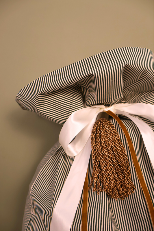 Close up of the Santa sack tied with cream satin ribbon, velvet ribbon and a gold tassel