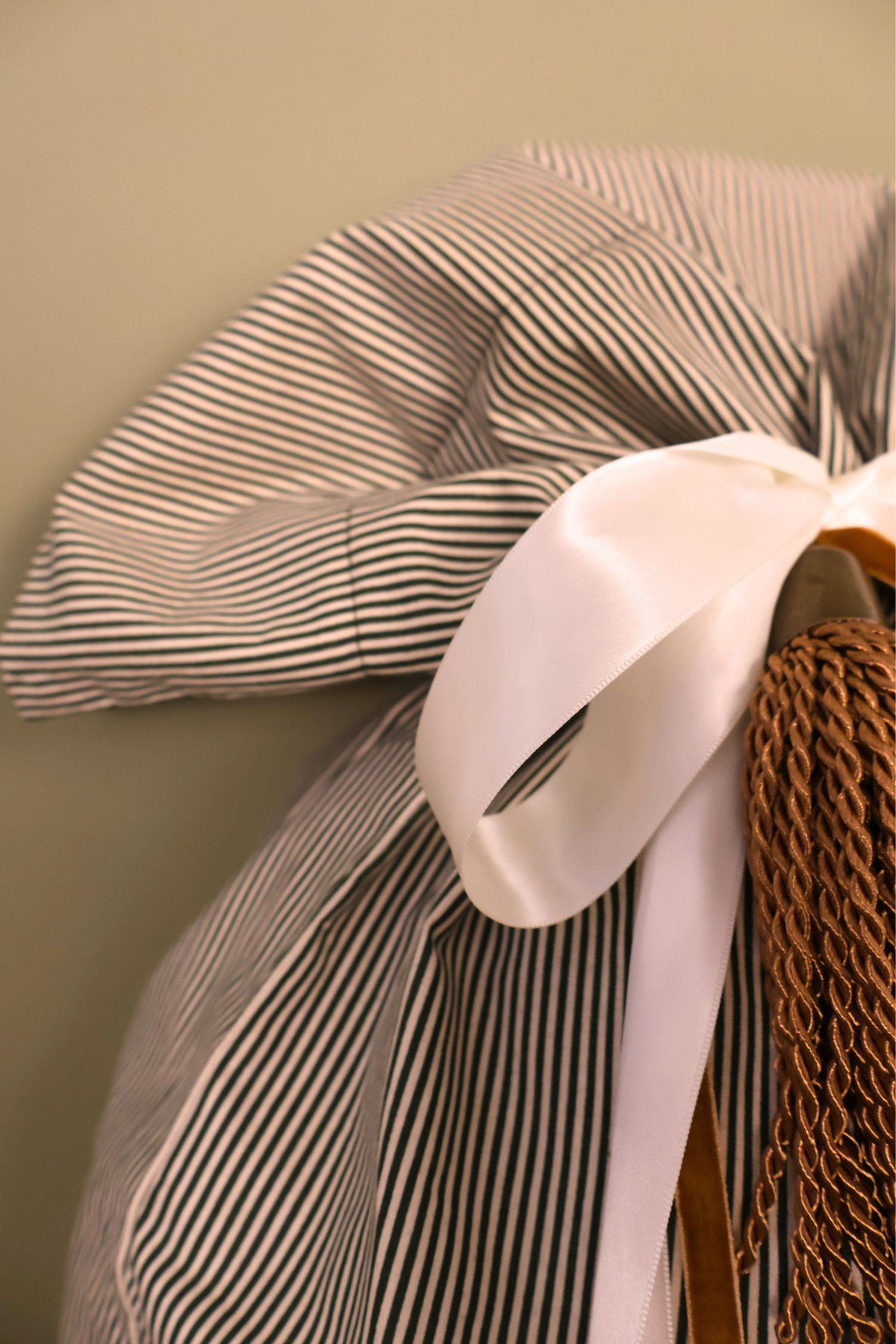 Cream satin bow on the gathered top of the green striped Santa sack