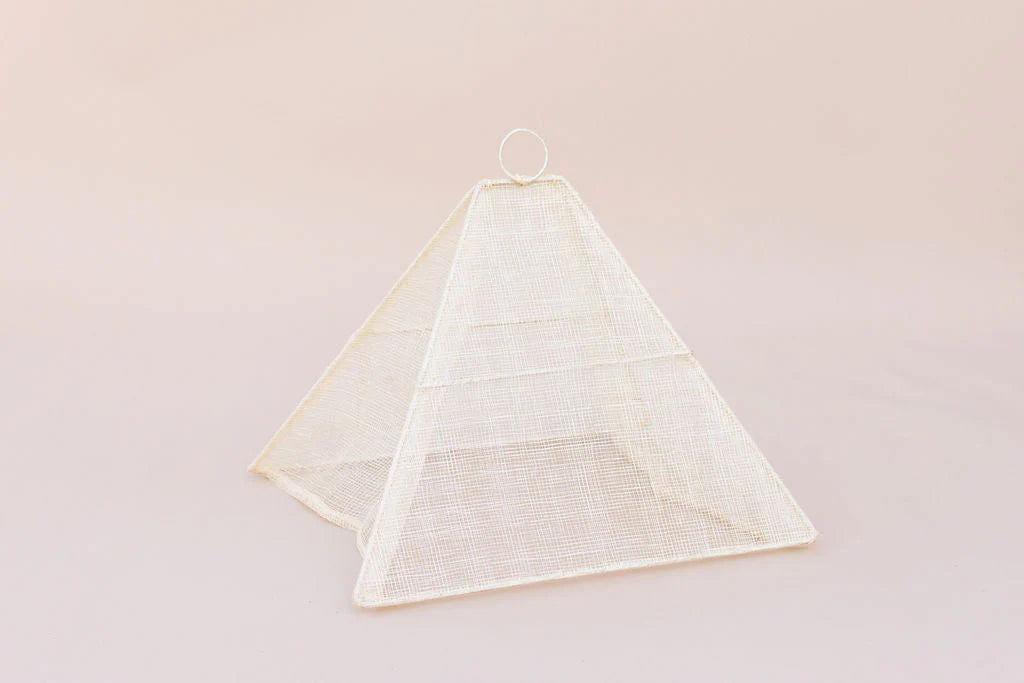 Small collapsible woven food tent cover in cream, on the table