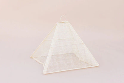 Small collapsible woven food tent cover in cream, on the table