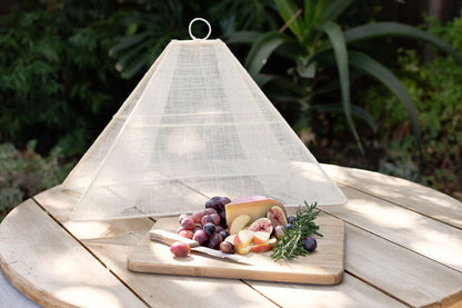 Small collapsible woven food tent cover in cream, styled setting